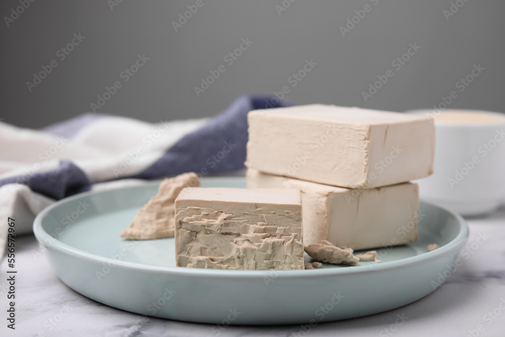 Blocks of compressed yeast on turquoise plate, closeup