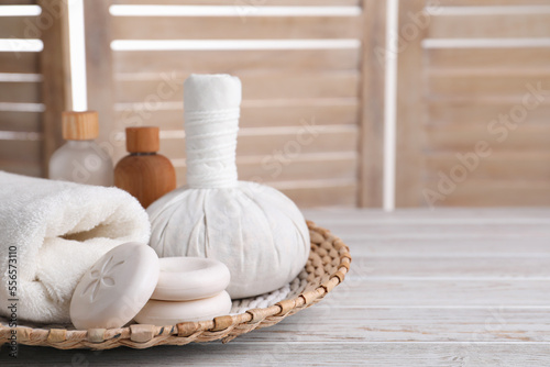 Spa composition with skin care products and wicker basket on white wooden table, space for text