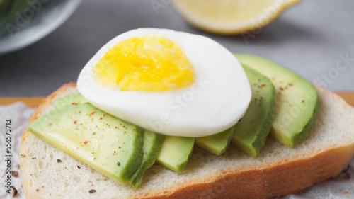 Delicious sandwich with boiled egg and pieces of avocado on table, closeup