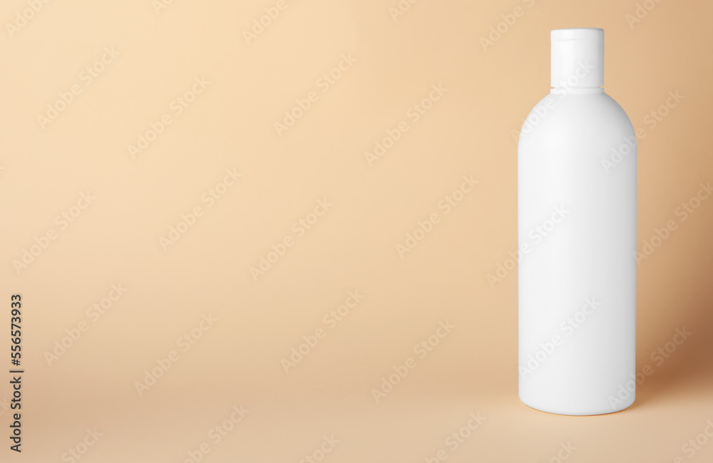 Bottle of shampoo on beige background, space for text Bottle of shampoo on beige background, space for text