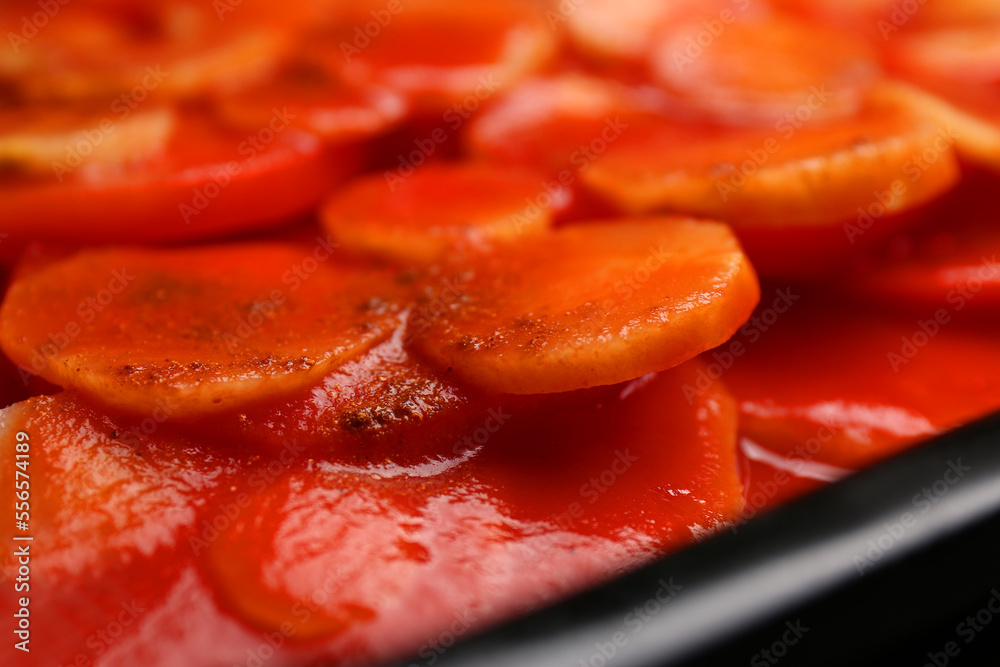 Tasty baked parsnips with red sauce, closeup