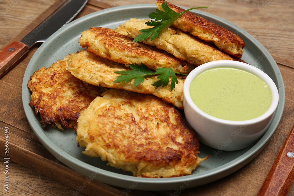 Tasty parsnip cutlets with sauce on wooden table, closeup Tasty parsnip cutlets with sauce on wooden table, closeup