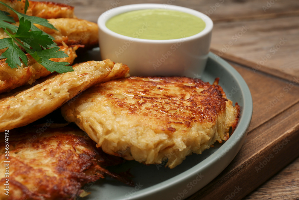 Tasty parsnip cutlets with sauce on wooden table, closeup Tasty parsnip cutlets with sauce on wooden table, closeup