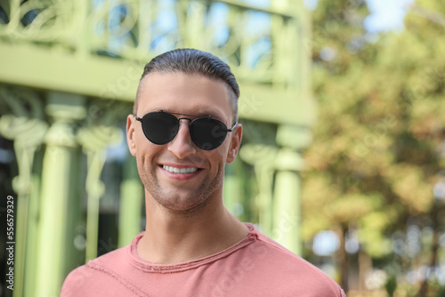 Portrait of handsome man in sunglasses outdoors, space for text