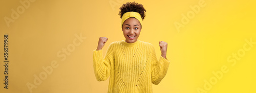Surprised cute tender african-american girl cannot believe win prize lottery clench fists triumphing smiling broadly widen eyes impressed astonished celebrating success, victory yellow background