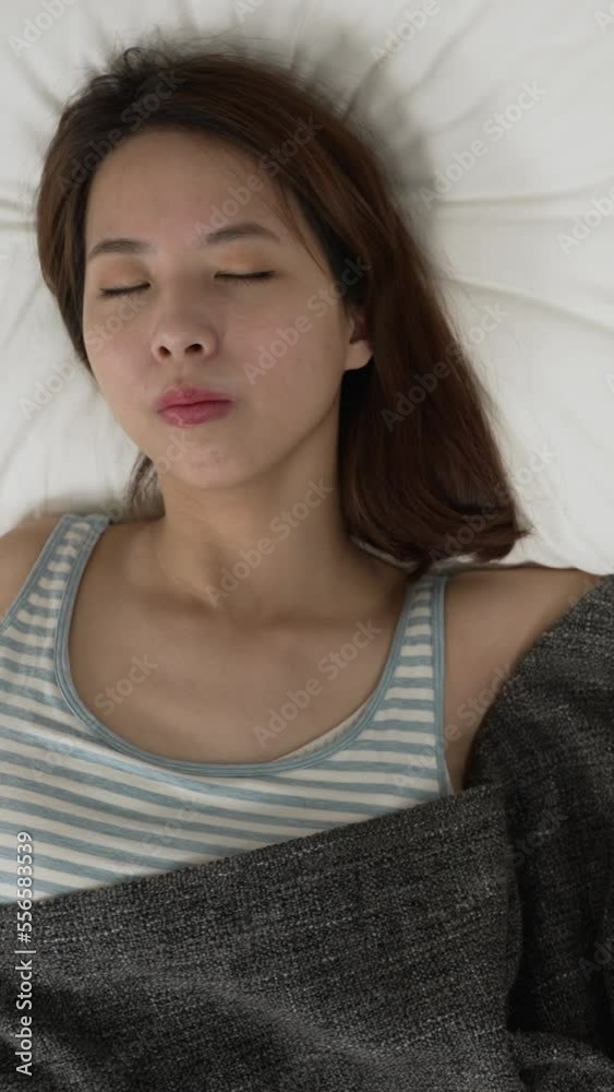 Vertical Screen: sleepy asian woman turning off alarm and hand hitting button on clock after sleepless night. angry and frustrated female sleeper feeling tired keep lying in bed Vertical Screen: sleepy asian woman turning off alarm and hand hitting button on clock after sleepless night. angry and frustrated female sleeper feeling tired keep lying in bed