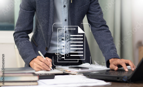 businessman work at office table and writing on notebook with checklist document, process to check and review everyting to do and have done photo