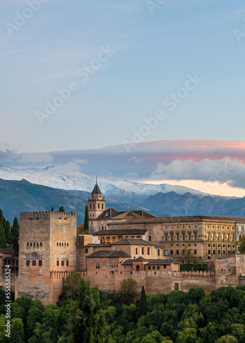 Aerial view of the Alhambra Palace in Granada, Spain with snow-capped Sierra Nevada mountains in the background.