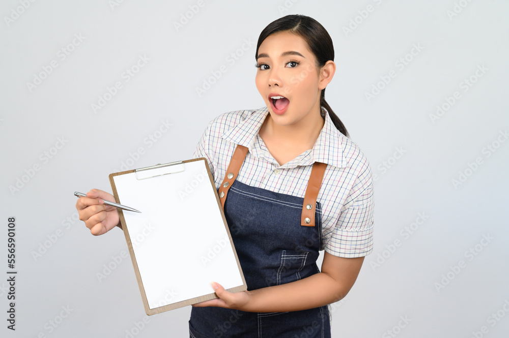 Portrait of young asian woman in waitress uniform pose with clipboard Portrait of young asian woman in waitress uniform pose with clipboard