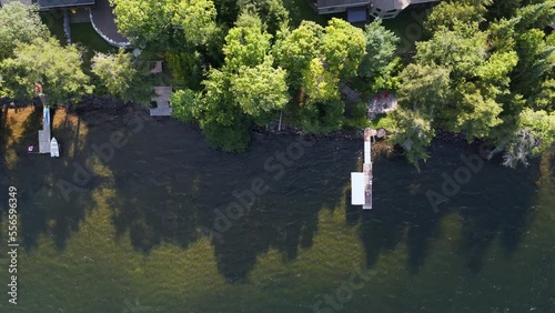 Top down drone shot of docks stretching out into lake during summer in cottage country of Ontario Canada photo