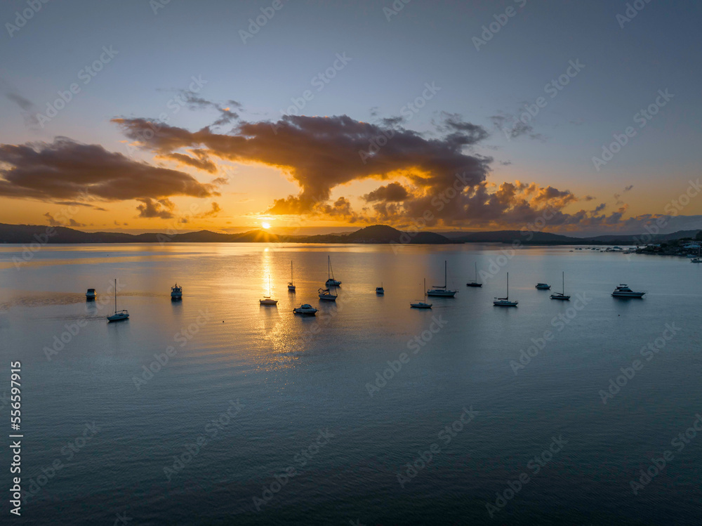 Aerial sunrise waterscape with boats, clouds and sun rays