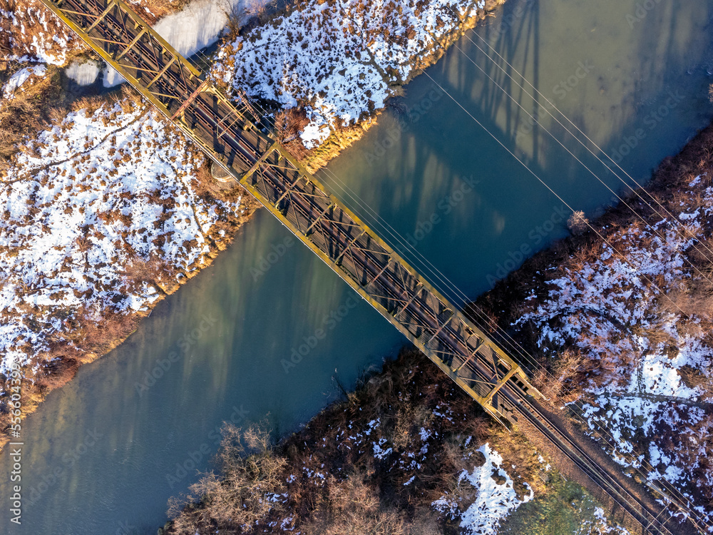 Aerial view. Old railroad bridge. Urban landscape. Winter, river, water, trees, nature, snow.