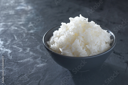 Obraz na płótnie Cooked rice in a black cup on black table as background. w salonie