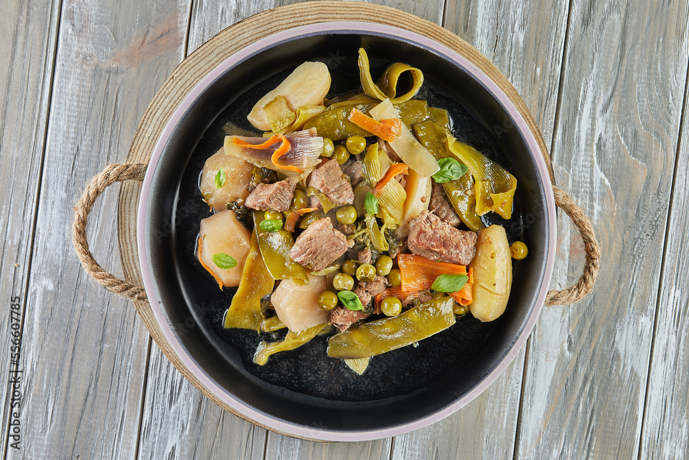 Lamb stew with seasonal vegetables on black plate Lamb stew with seasonal vegetables on black plate