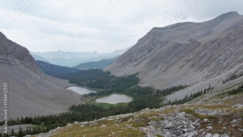 Hiker taking photos walking through mountain amphitheater pan photo