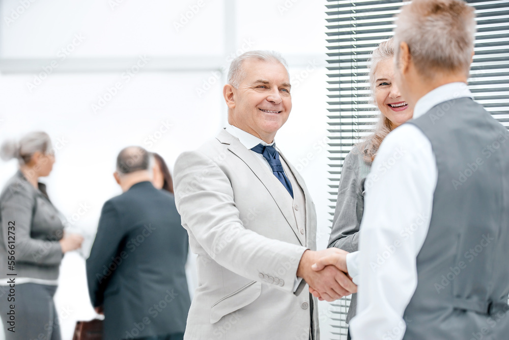 close up. serious business man shaking hands with his colleague