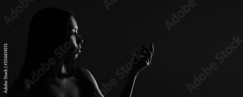 Dark female silhouette, hands and face. Artistic portrait. Required photo of the woman's body. Black and white silhouette of female body art photography.