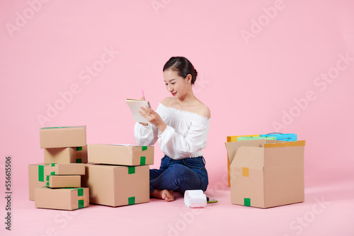 Young beautiful asian woman prepare to send products by orders to her costomers