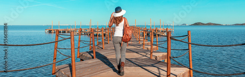 Woman walking on wooden pier