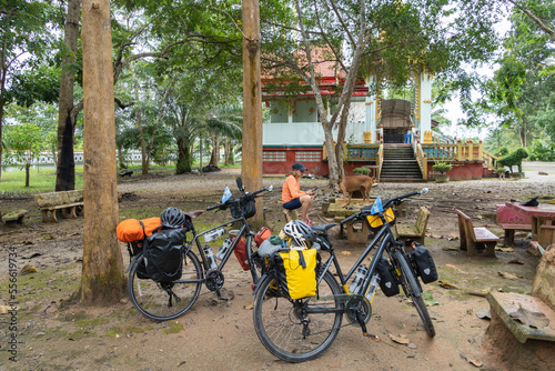 cyclist woman resting in buddhist temple and Two Bikepacking bicycle with saddlebags and camping gear photo