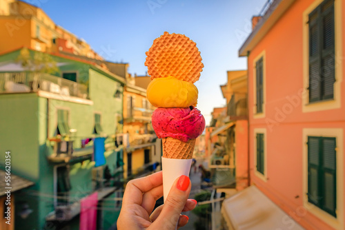 Fototapeta Naklejka Na Ścianę i Meble -  Hand with gelato and view of traditional houses in Manarola, Cinque Terre, Italy