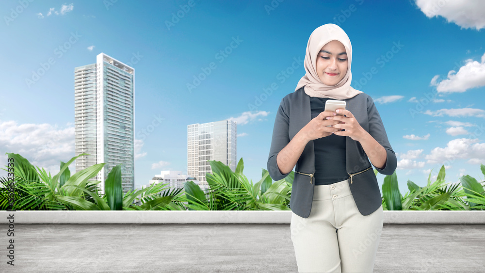 Muslim woman in a headscarf using a mobile phone