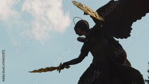 Archangel statue at a midday sky background, static view with clouds slowely moving. Interesting object to visit during city tour. Peaceful day in a big city. High quality 4K footage photo