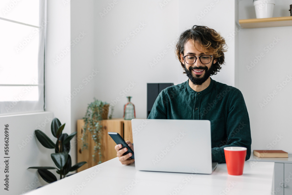 Happy mature businessman using laptop at desk Happy mature businessman using laptop at desk