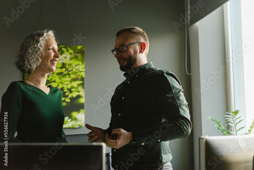 Smilinig businessman and businesswoman talking in office photo