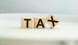 TAX text on wooden block with white backgrounds.