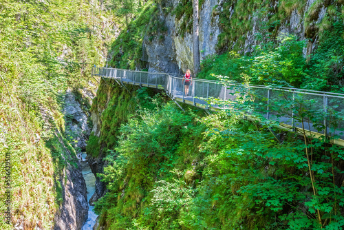 Austria, Female hiker walking along bridge stretching over Leutasch Gorge photo