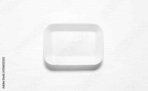 White styrofoam tray against a white wood board