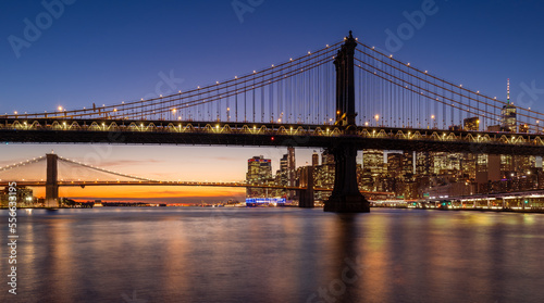 Manhattan Bridge and Brooklyn Bridge with East River just after sunset. Lower Manhattan skyline at dusk, New York City