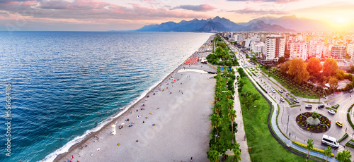 Fototapeta Naklejka Na Ścianę i Meble -  Aerial view of scenic and popular Konyaalti beach in Antalya resort town. Majestic mountains with haze in the background. Vacation and holiday in Turkiye