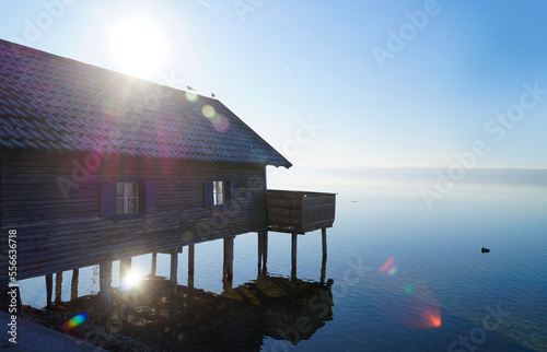 an old wooden boat house in Herrsching on calm lake Ammersee in Bavaria on a clear and sunny January evening (Herrsching, Bavaria, Germany) photo