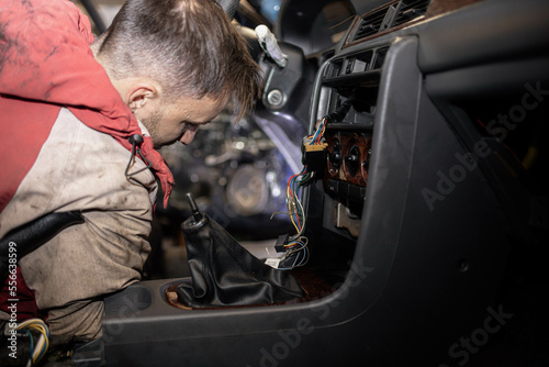 disassemble the center console of the car torpedo for interior detailing and repair. © velimir