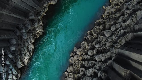 top down view aerial shot drone of studlagil canyon,river water flowing into basaltic rock formation,iceland nature