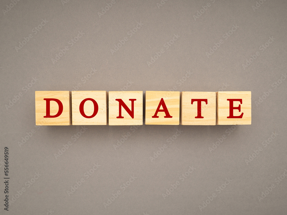 Top view of wooden cubes with the letters DONATE on a gray background Top view of wooden cubes with the letters DONATE on a gray background