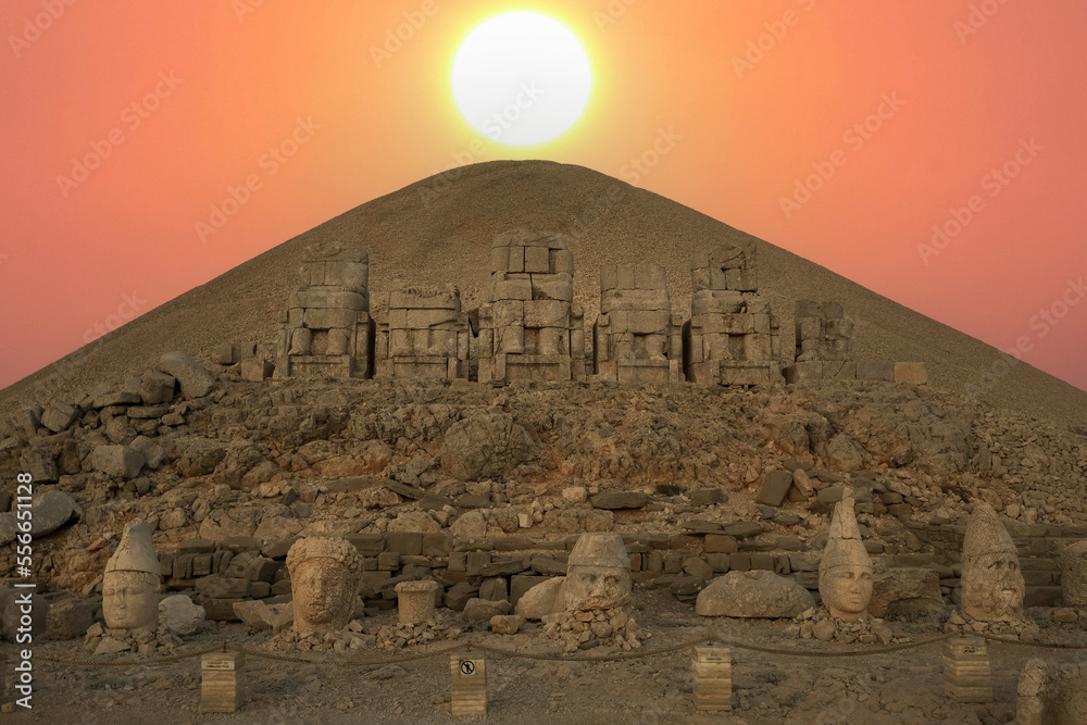 View of mount Nemrut and monumental sculptures of commagene kings and gods with colorful clouds and sun at sky View of mount Nemrut and monumental sculptures of commagene kings and gods with colorful clouds and sun at sky