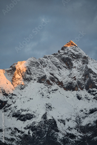 Sun kissed snow covered mountain summit peak