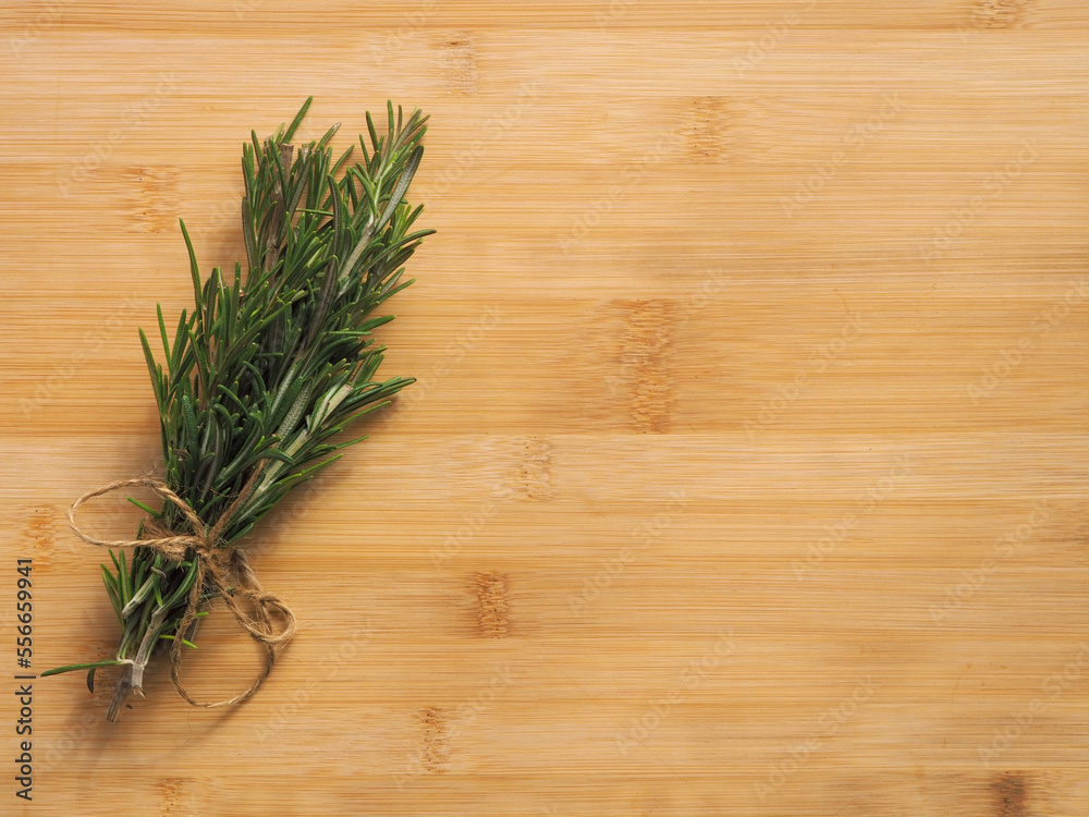 Bunch of rosemary herb on the wooden board background Bunch of rosemary herb on the wooden board background