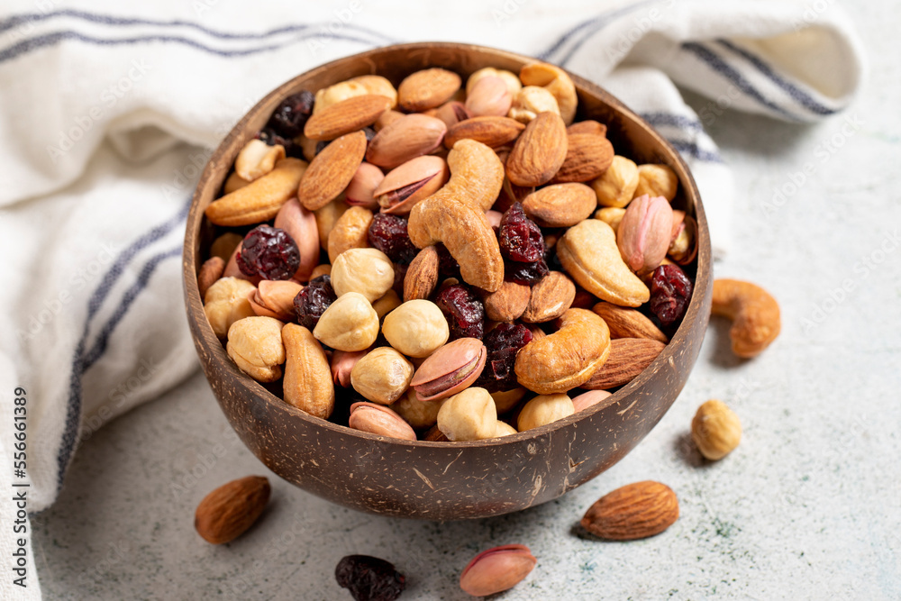 Mixed nuts in bowl on gray background. Nuts, cashews, almonds and pistachios in a coconut bowl. close up Mixed nuts in bowl on gray background. Nuts, cashews, almonds and pistachios in a coconut bowl. close up