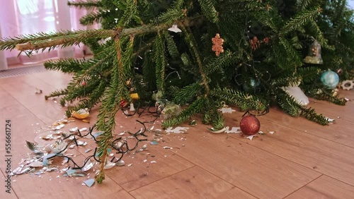 Fallen Over Christmas Tree with Broken Glass Baubles Decorations Shattered on Floor