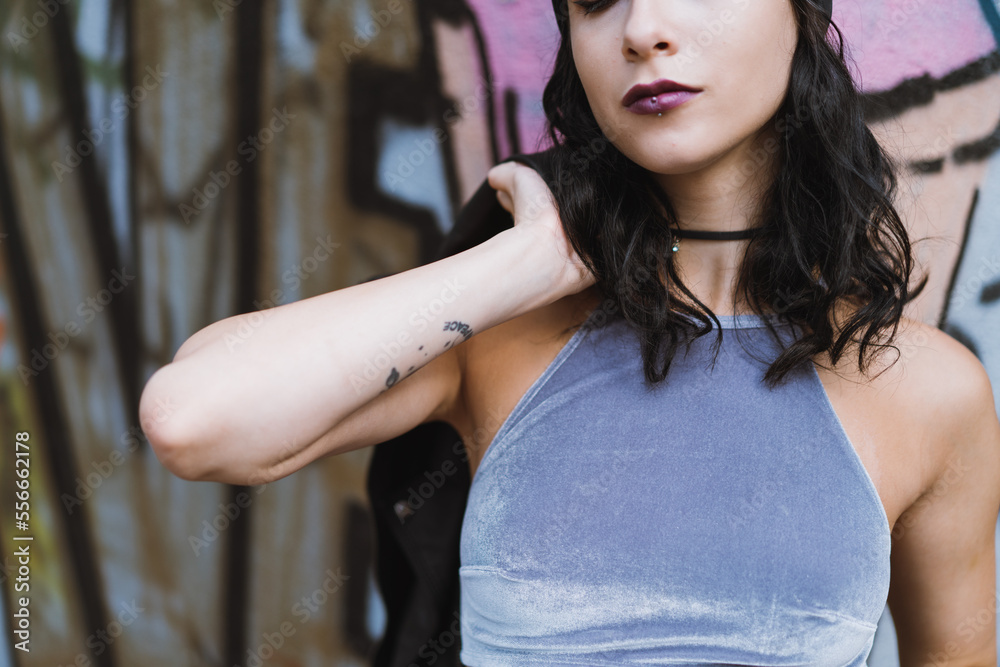 Fototapeta premium Young adult model holding a leather jacket on her shoulder looking at camera in a sensual way.