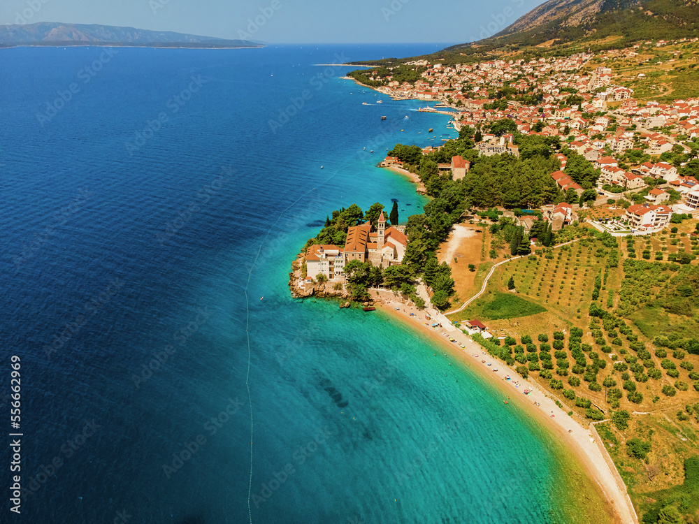 Croatia, Brac island, Bol. Aerial view of pebble beach and Dominician monastery on Adriatic sea