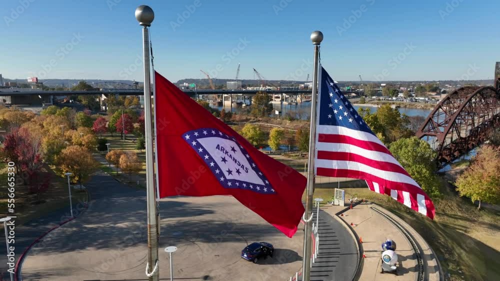 Arkansas state and USA flag on sunny day during golden hour light. Aerial view at Little Rock.