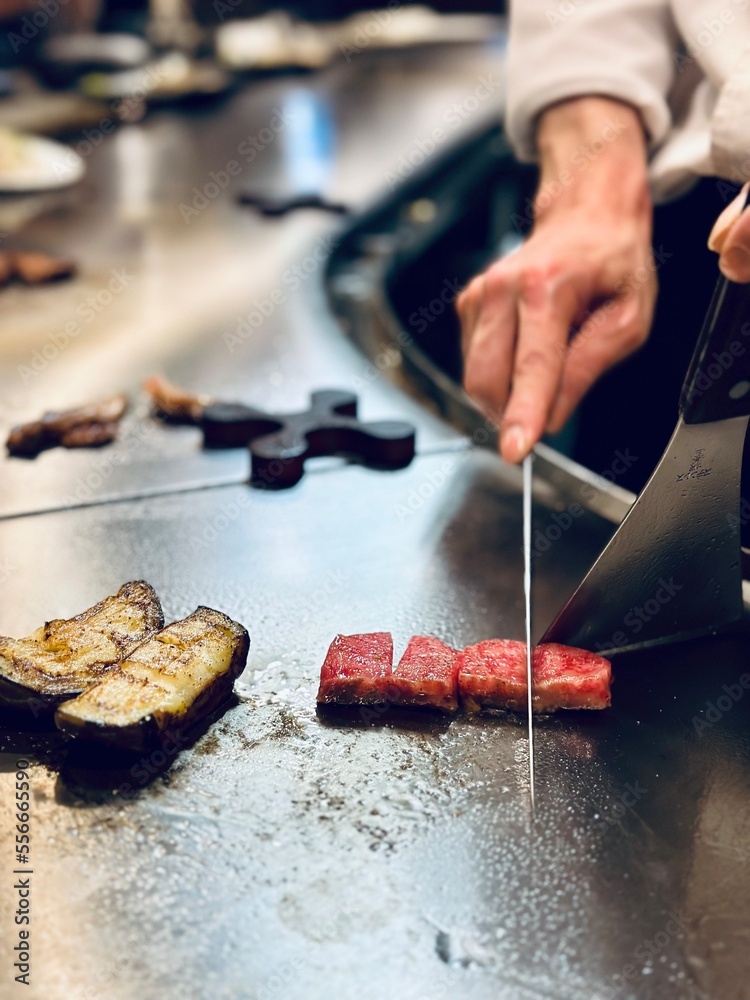 Fototapeta premium Chef slicing Kobe beef in the traditional style on a teppanyaki grill in Kobe Japan