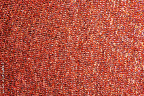 Knitted fabric textured background. Knitting. Colorful red-orange knitted pattern. Red yarn.