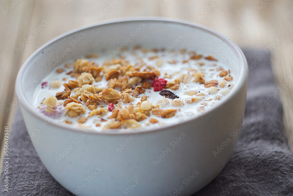 A plate of muesli stands on a wooden table. Selective focus A plate of muesli stands on a wooden table. Selective focus