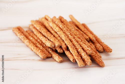 Long dry sesame bread sticks on a marble background
